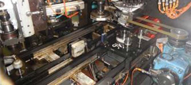 Intérieur de la machinerie, encombré d'équipements et de câbles. Comprend des rails métalliques et des composants de machine.