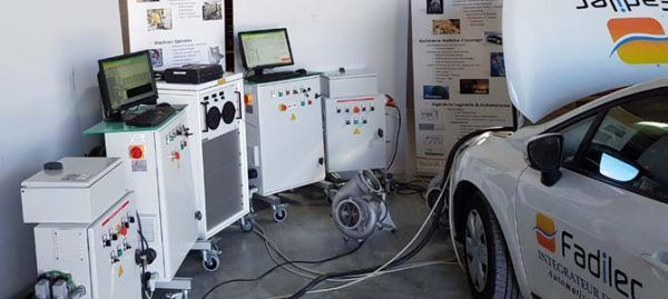 Une voiture blanche testée par des machines. Le logo Fadiler est visible.