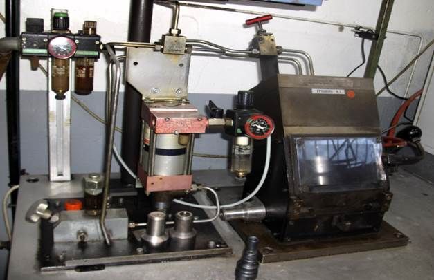 Machine industrielle avec jauges, tuyaux et fenêtre de visualisation, probablement destinée à la fabrication ou au traitement.