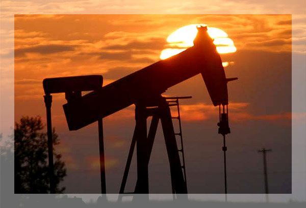 Pompe à huile se découpant sur un coucher de soleil, extrayant du pétrole du sol.