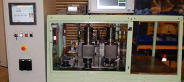 Panneau de contrôle avec écran d'affichage, boutons et machines derrière un cadre de fenêtre.