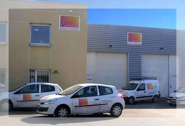 Des véhicules d'entreprise devant le bâtiment de chez Fadilec.