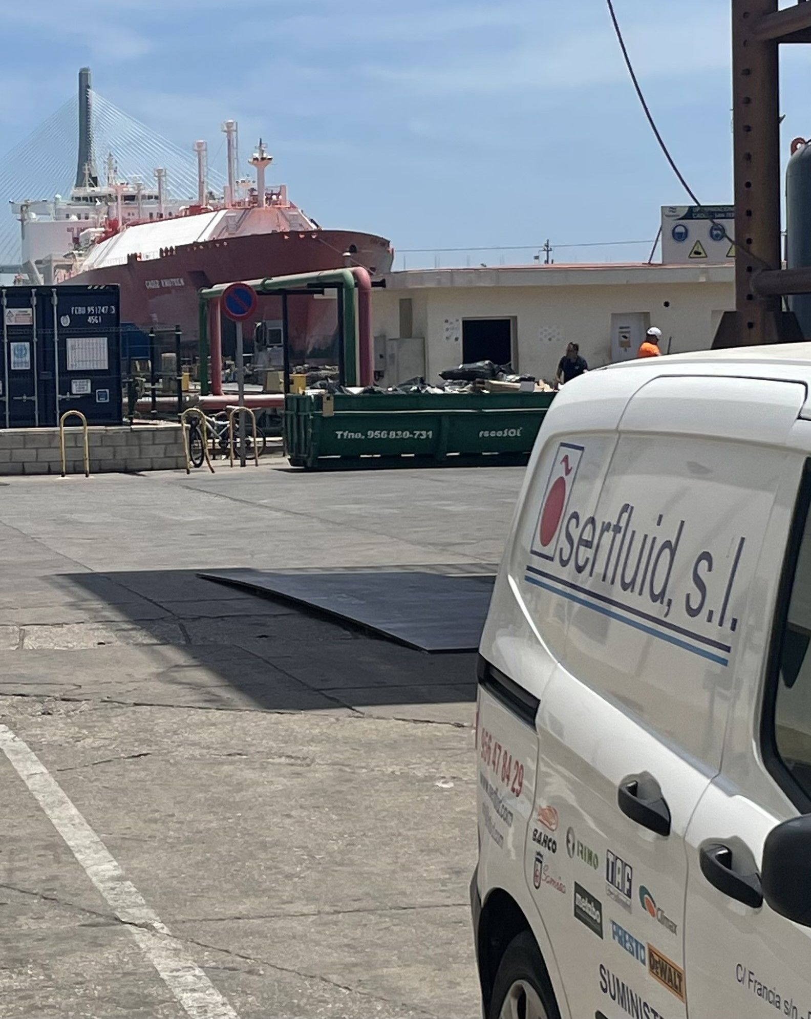Una camioneta blanca que dice 'serfluid sl' en el costado está estacionada en un estacionamiento