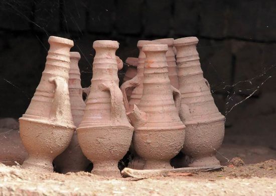Un grupo de jarrones de arcilla están alineados en fila.