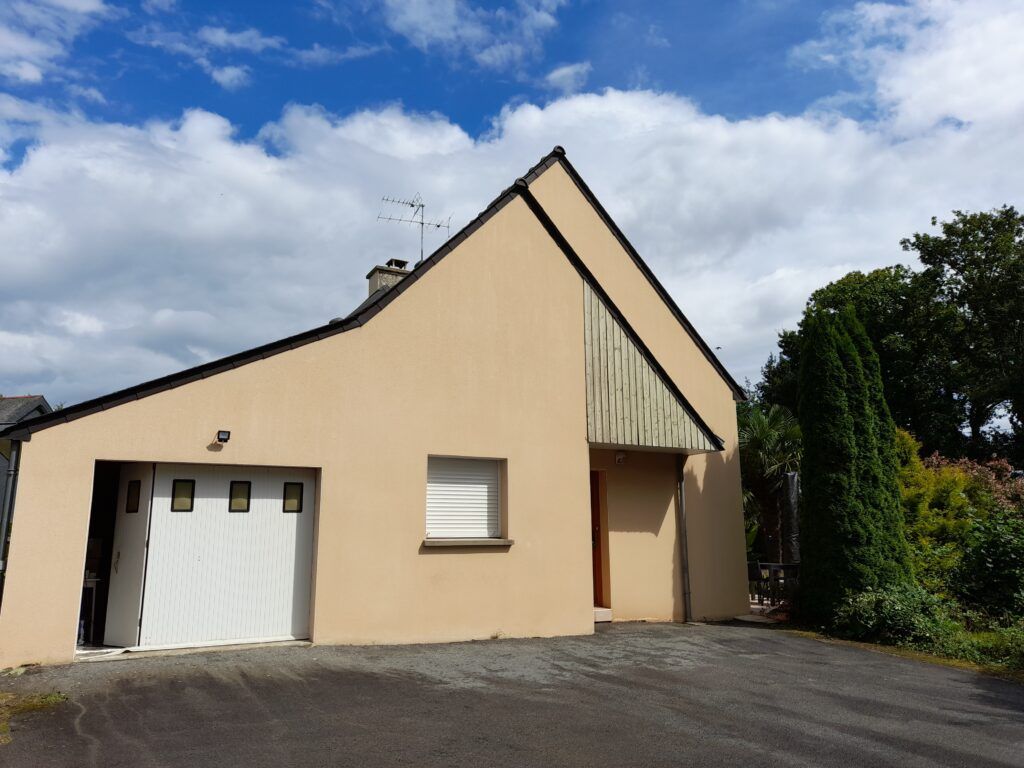 Une maison beige avec une porte de garage blanche