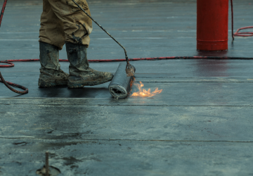 Une personne se tient sur un toit avec une torche.