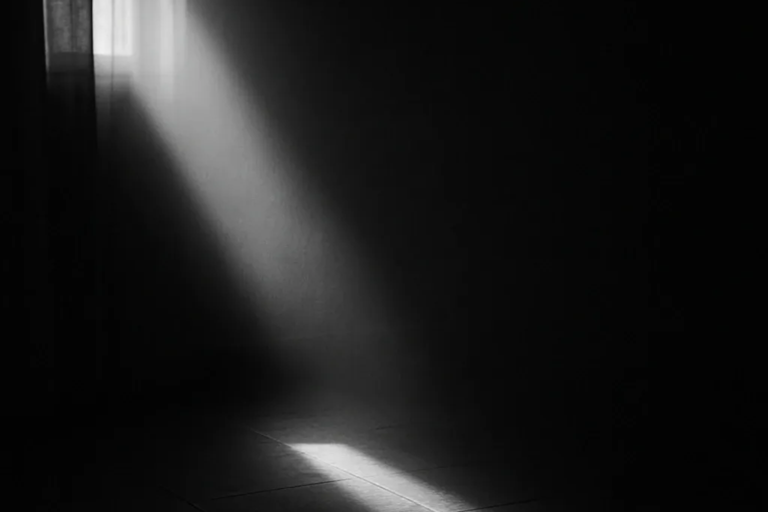Helles Sonnenlicht strömt durch ein Fenster und erhellt einen dunklen Raum.