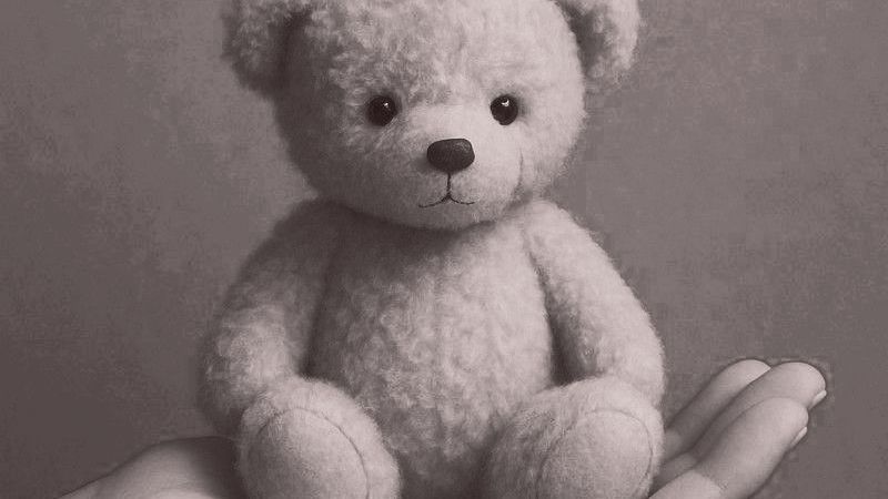 Teddybär sitzt in einer Hand, neutraler Ton, konzentrierter Blick, weiches Fell.