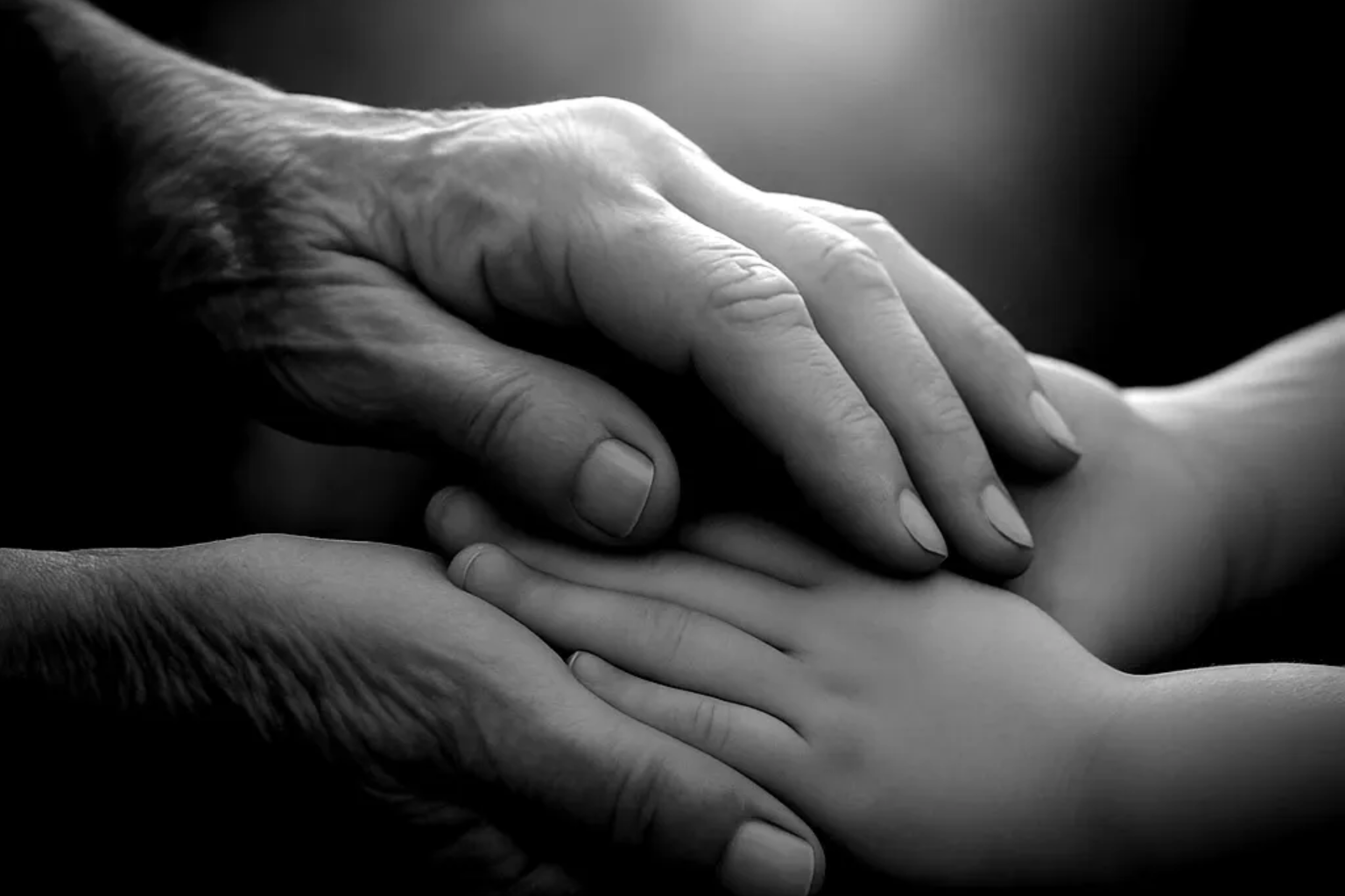 Gesunde Trauer braucht Zeit, Realität und echte Begegnung. Was moderne Trauerforschung heute weiß und warum das für die Trauerbegleitung wichtig ist. Zwei Hände, die sanft eine kleinere Hand halten – in Schwarz-Weiß