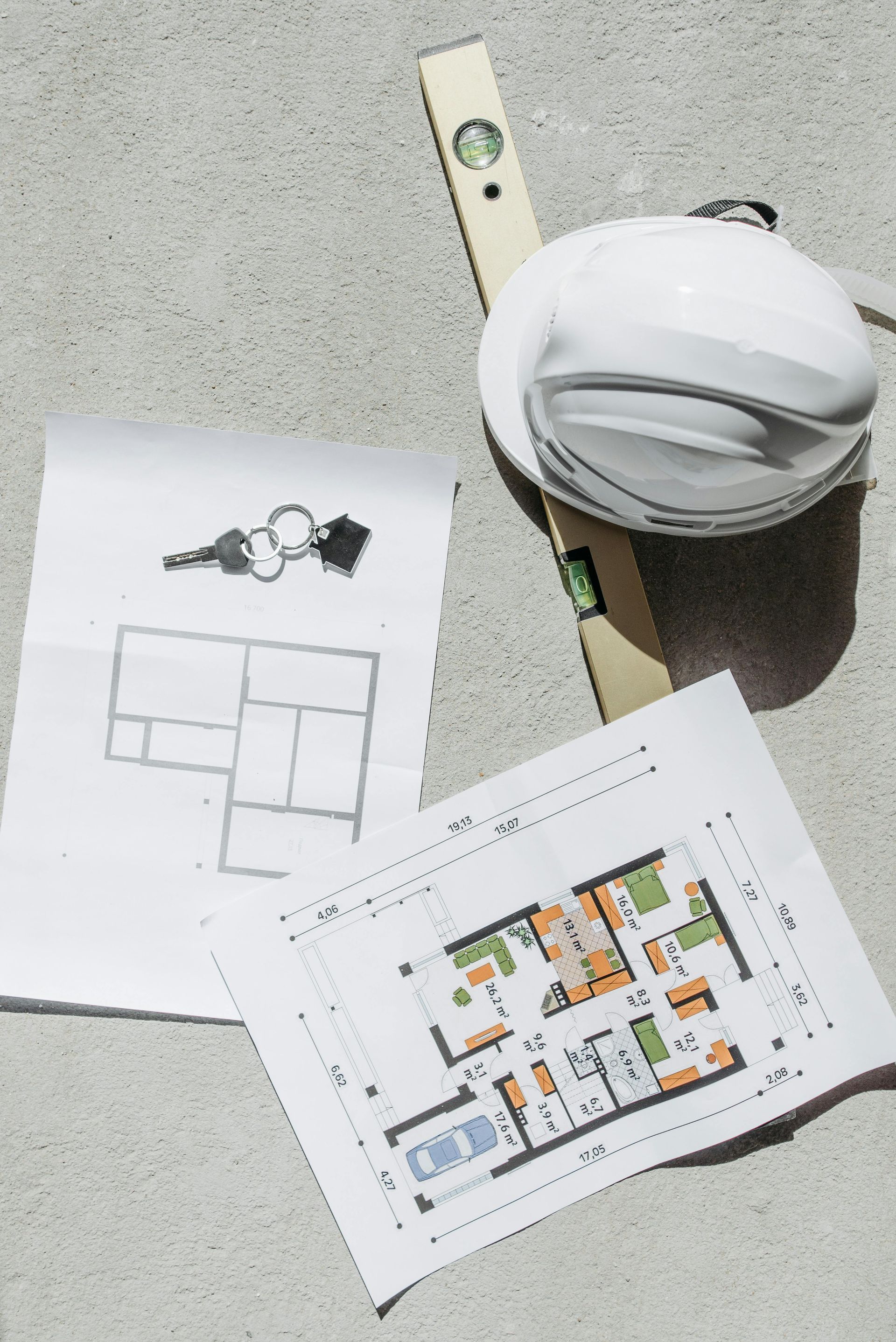 Casque de chantier, mètre ruban et plans architecturaux sur une surface en béton