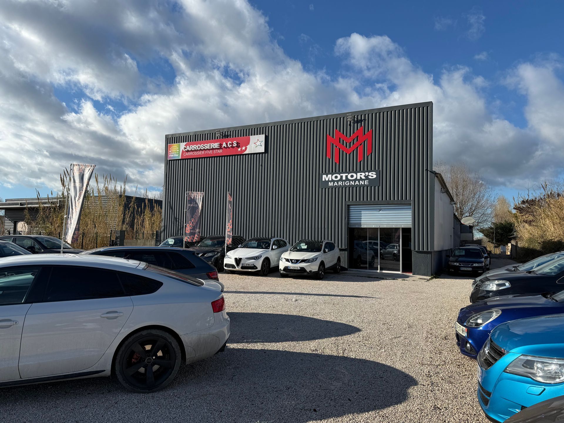 Voiture de sport Porsche argentée avec des accents noirs et vert fluo, garée à l'extérieur.