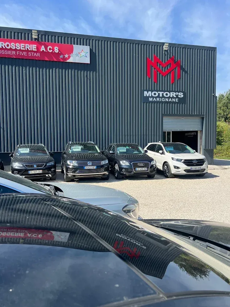 Des voitures de sport Lamborghini rouges et Honda NSX sur une route de montagne sous un ciel nuageux.
