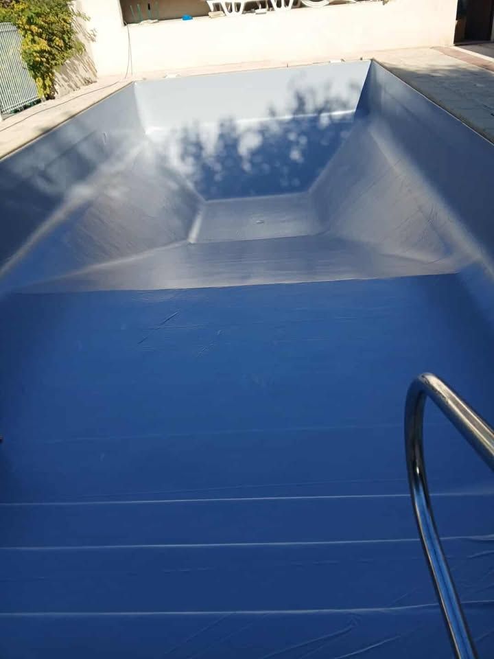 Piscine avec échelle, eau bleue et mur de briques et pompe à chaleur.