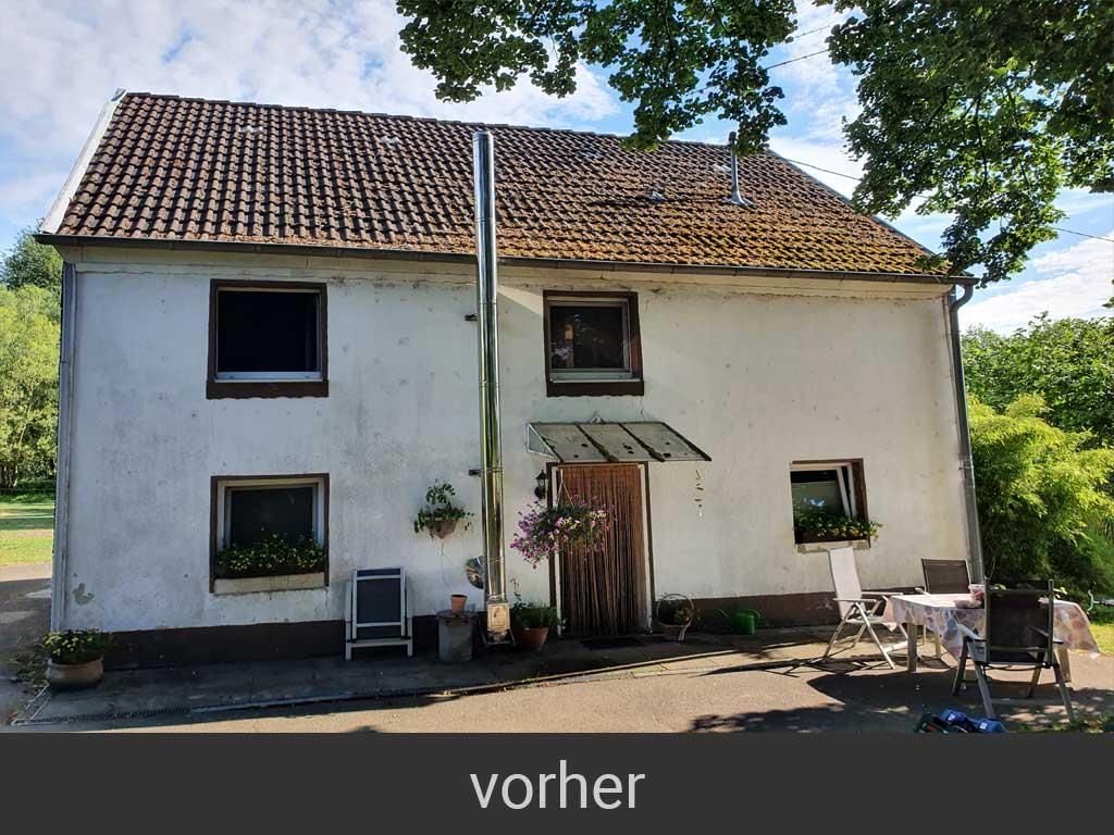 Ein weißes Haus mit einem Dach, auf dem sich ein Schornstein befindet