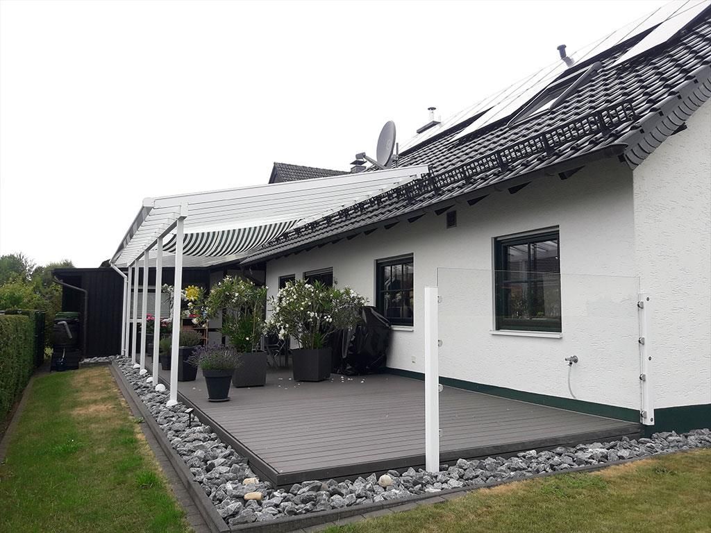 Ein weißes Haus mit einer großen Terrasse davor.