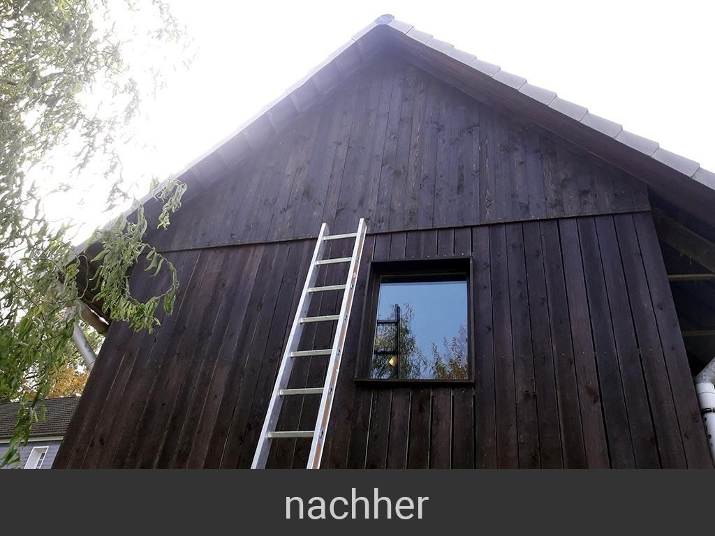 Eine Leiter steht an der Seite eines Holzgebäudes