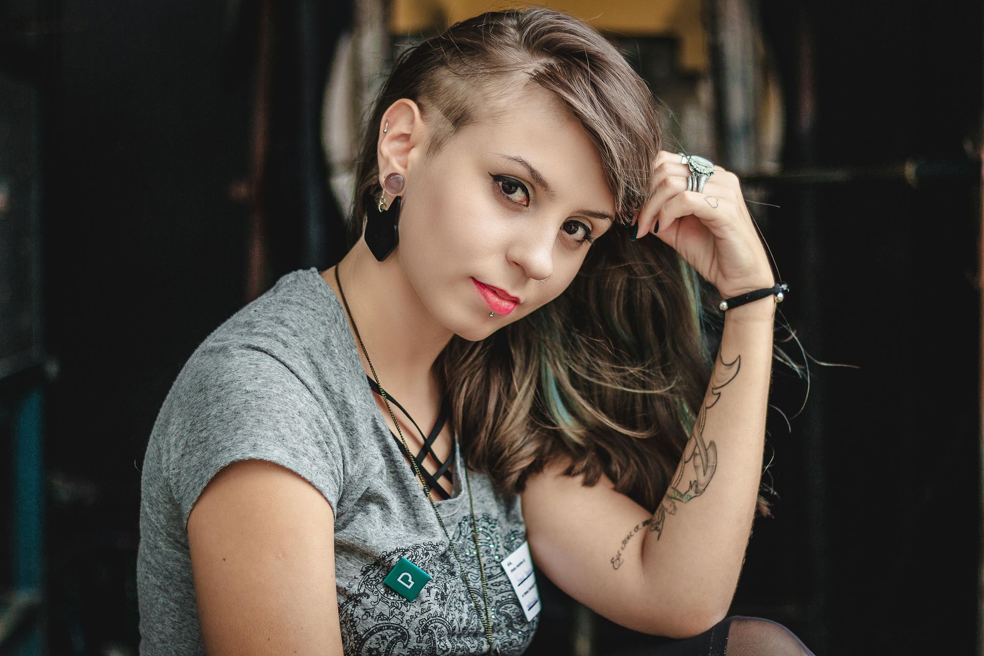 Una mujer con la cabeza rapada y un tatuaje en el brazo.