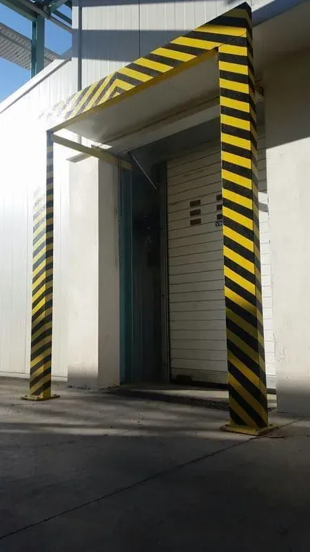 Marco de seguridad con rayas amarillas y negras alrededor de una puerta de muelle de carga.