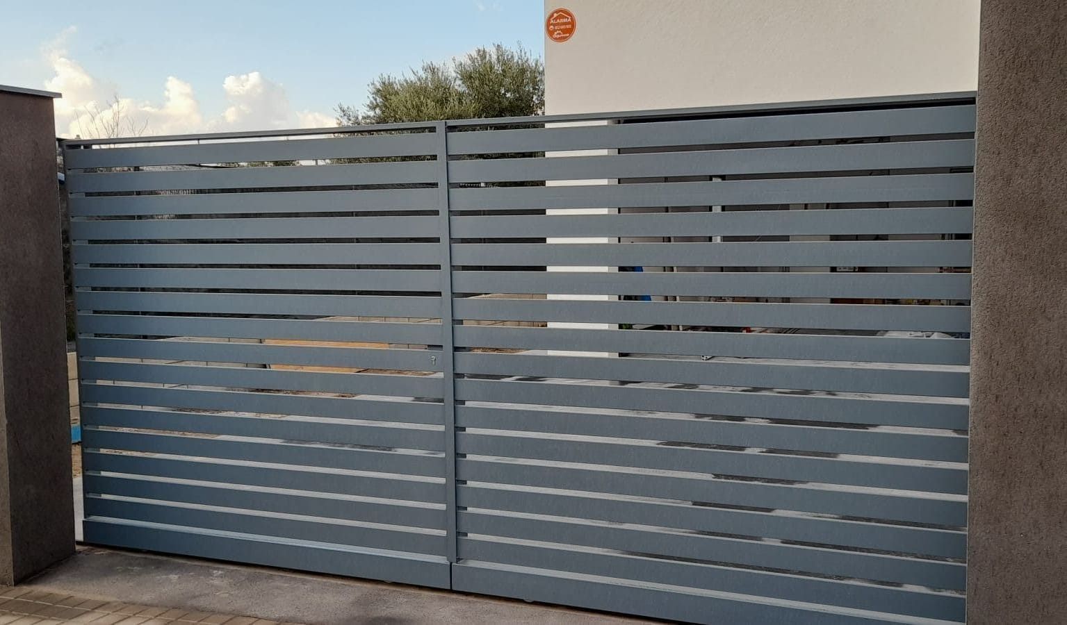 Puerta de entrada con listones horizontales de color gris.