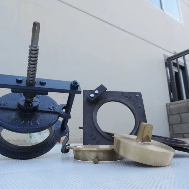 Piezas metálicas de color negro y latón, entre las que se incluyen una polea, un anillo y un disco.