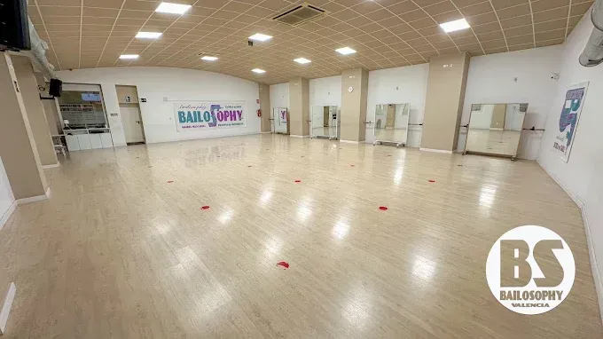 Estudio de danza interior vacío, con suelo de madera, espejos y luces en el techo