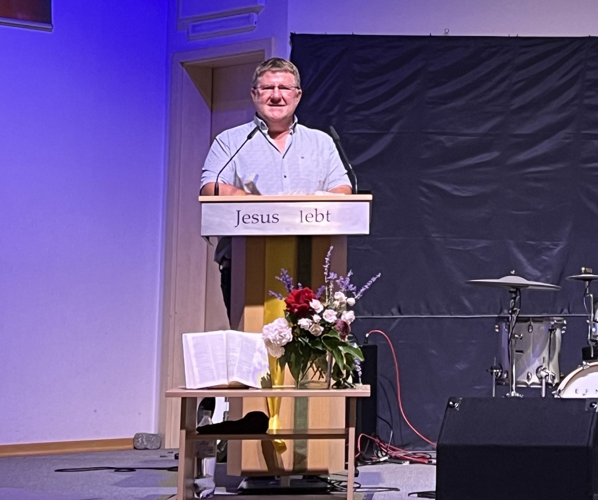 Ein Mann steht an einem Podium, auf dem Jesus steht