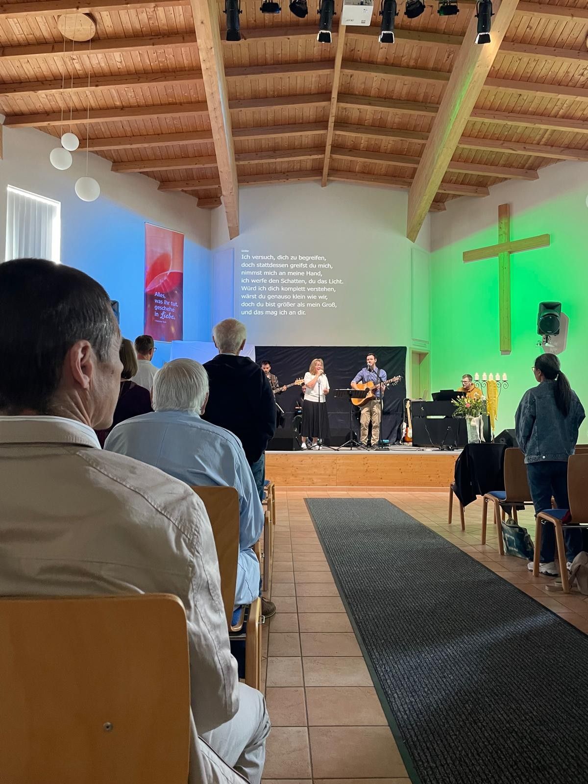 Eine Gruppe von Menschen sitzt in einer Kirche und sieht sich ein Konzert an.