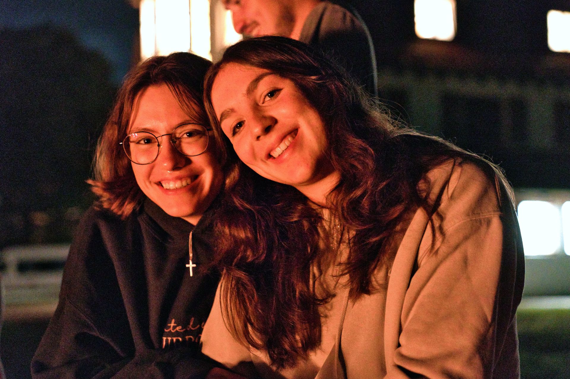 Zwei Mädchen posieren vor einem Kaminfeuer für ein Foto.