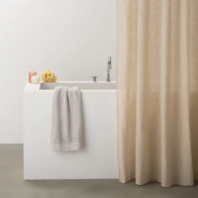 Una bañera con una cortina de ducha colgando sobre ella