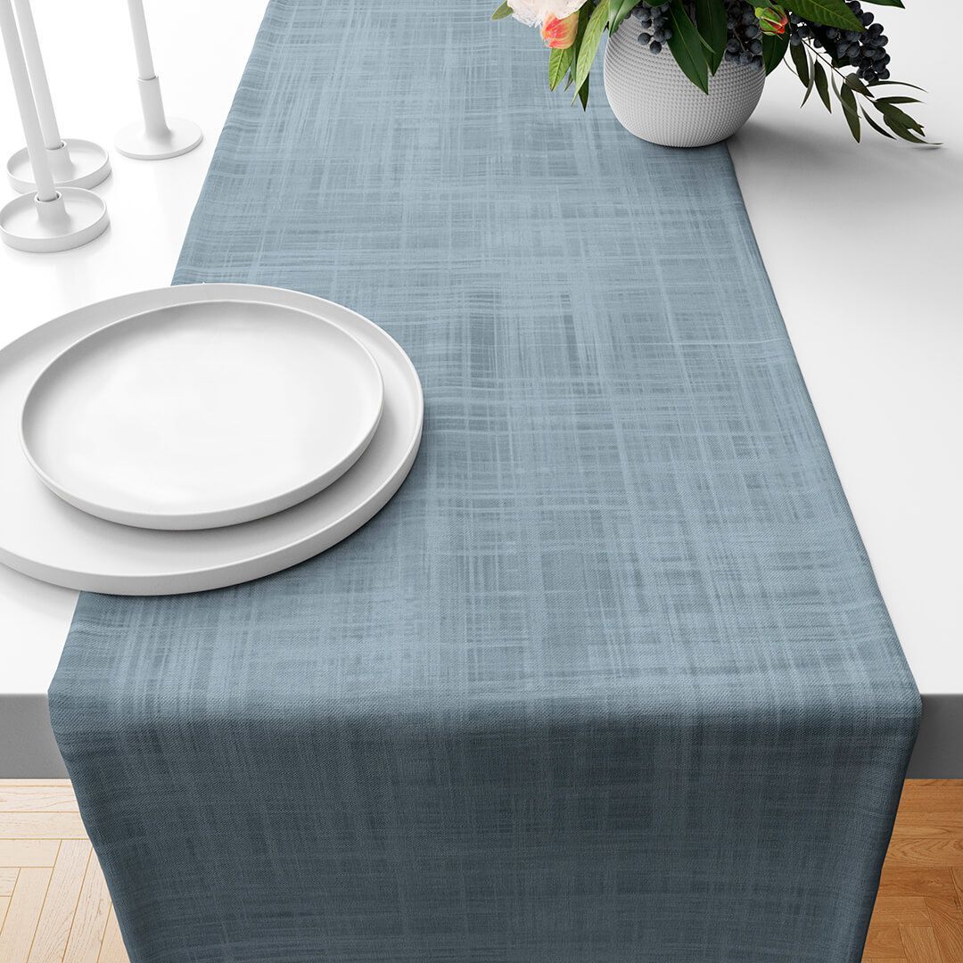 Una mesa con platos y un jarrón de flores encima.