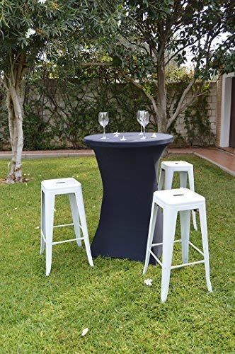 Una mesa y taburetes están colocados sobre un exuberante campo verde.