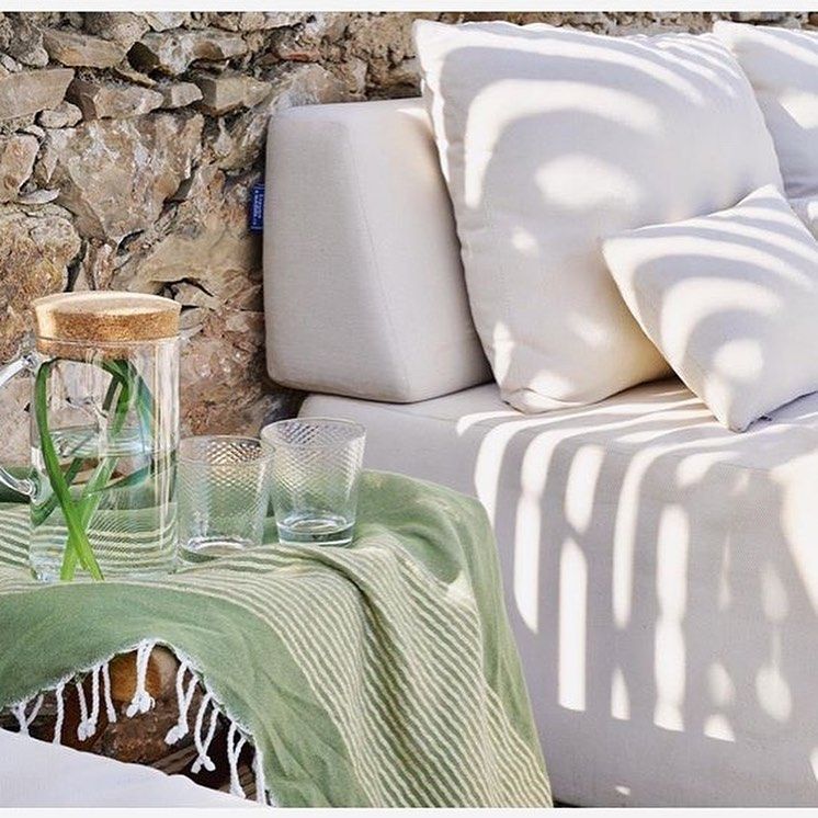 Una mesa con una jarra y dos vasos encima.