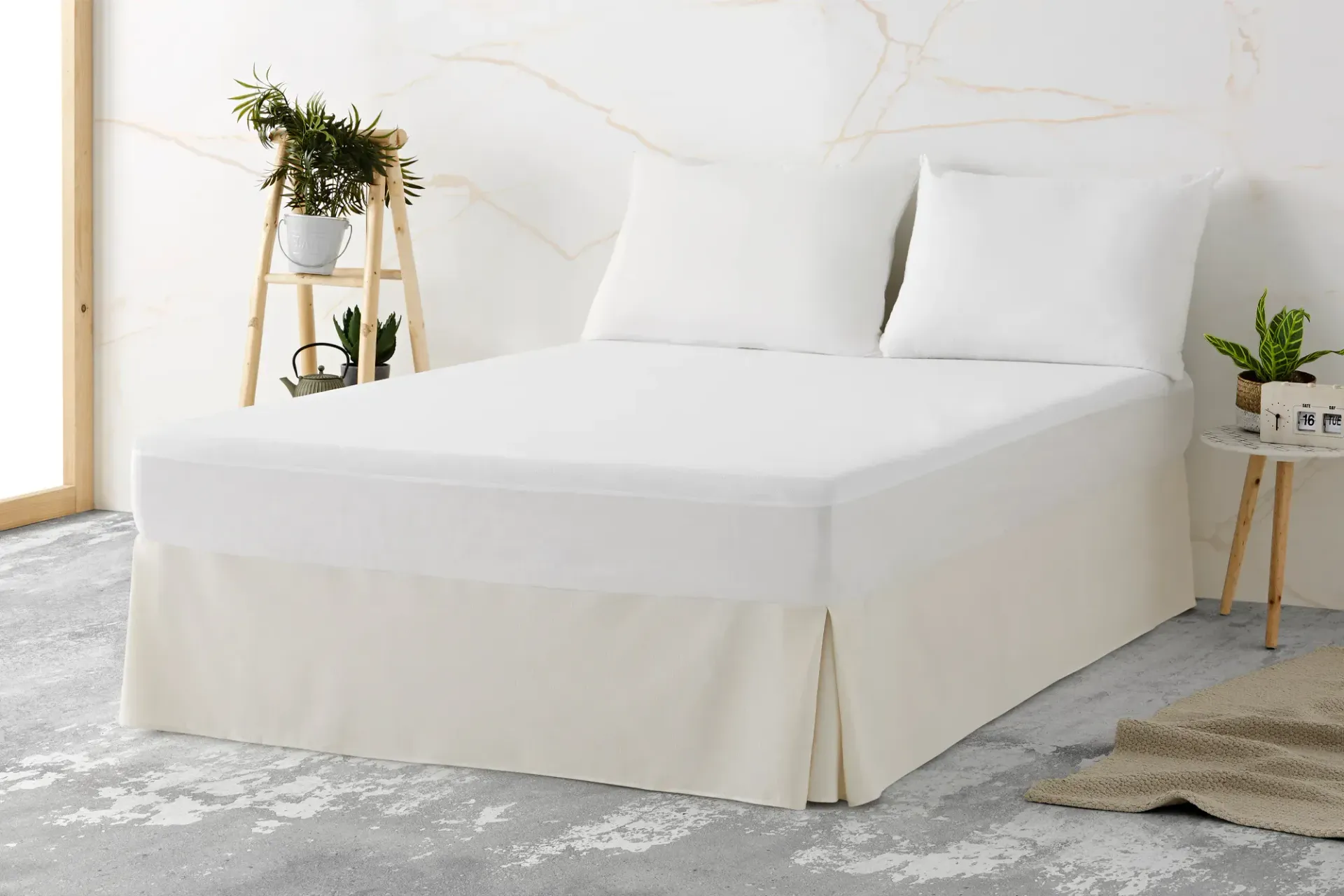 Una cama con sábanas blancas y almohadas en un dormitorio.