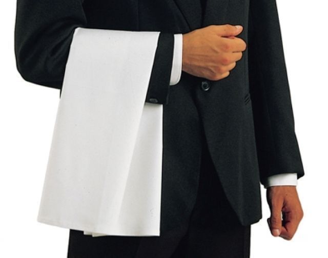 Un hombre con traje sostiene una toalla blanca alrededor de su cintura.