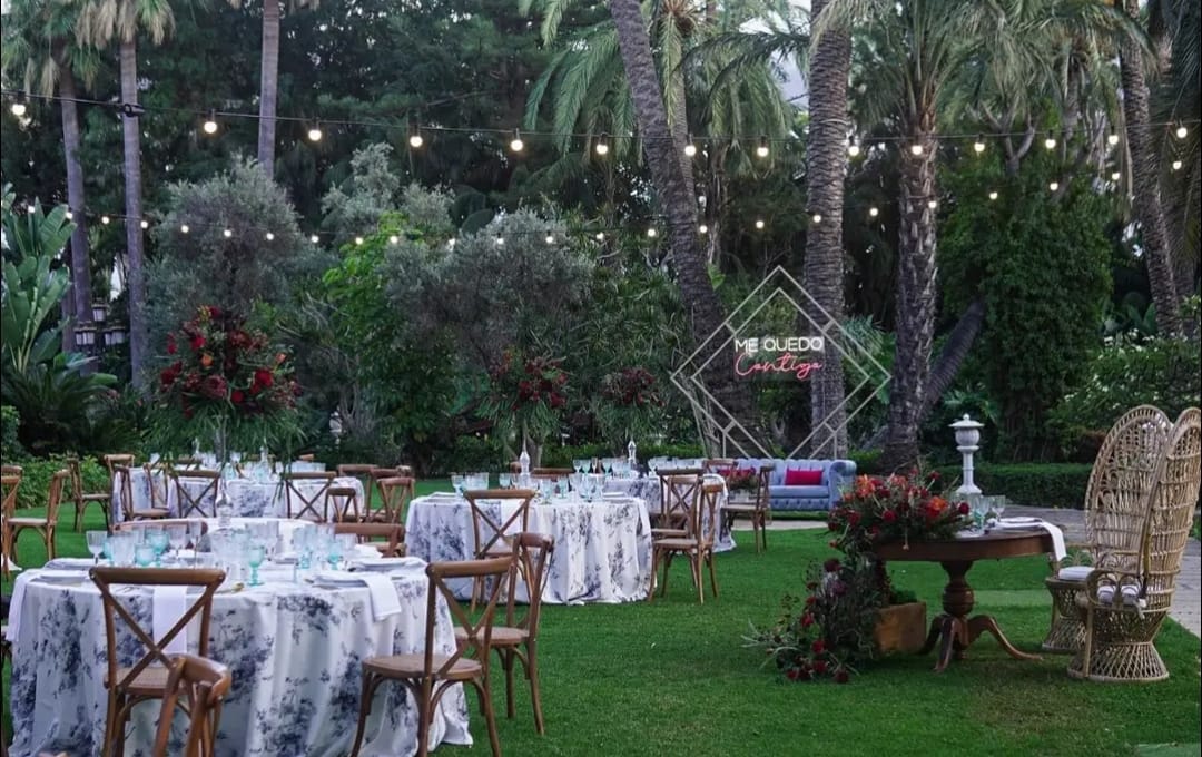 Un césped con mesas y sillas preparadas para una recepción de boda.