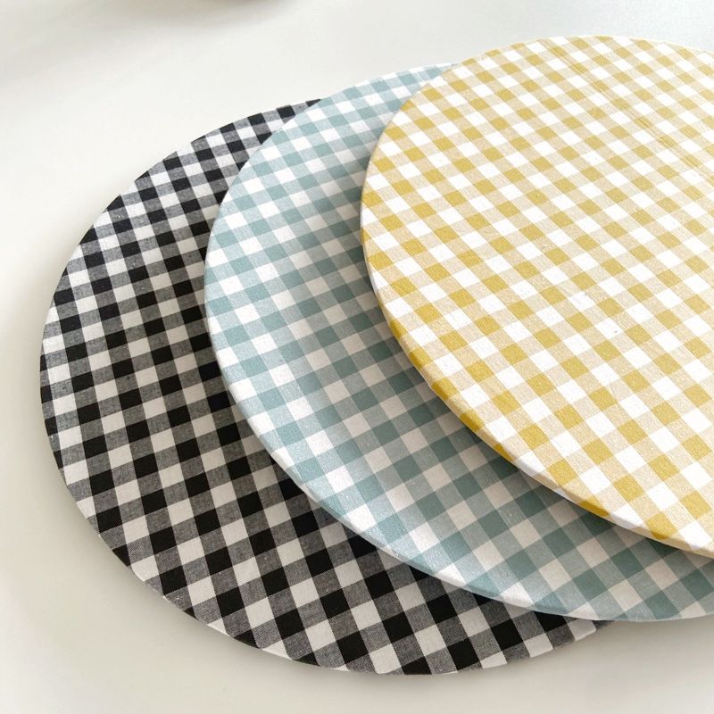 Tres platos a cuadros se apilan uno encima del otro sobre una mesa.