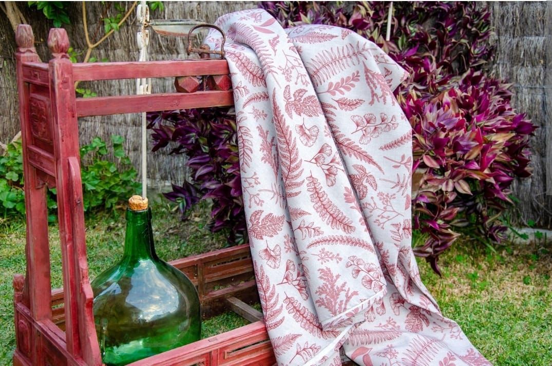 Una manta está encima de una caja de madera al lado de una botella verde.