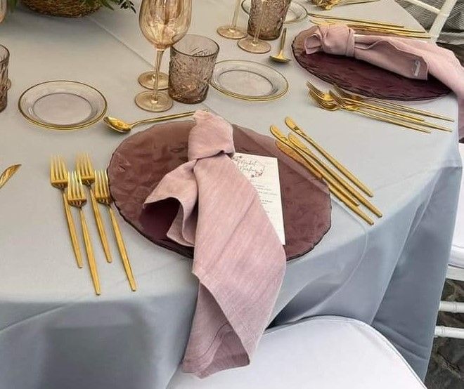 Una mesa con platos, cubiertos y una servilleta sobre ella.