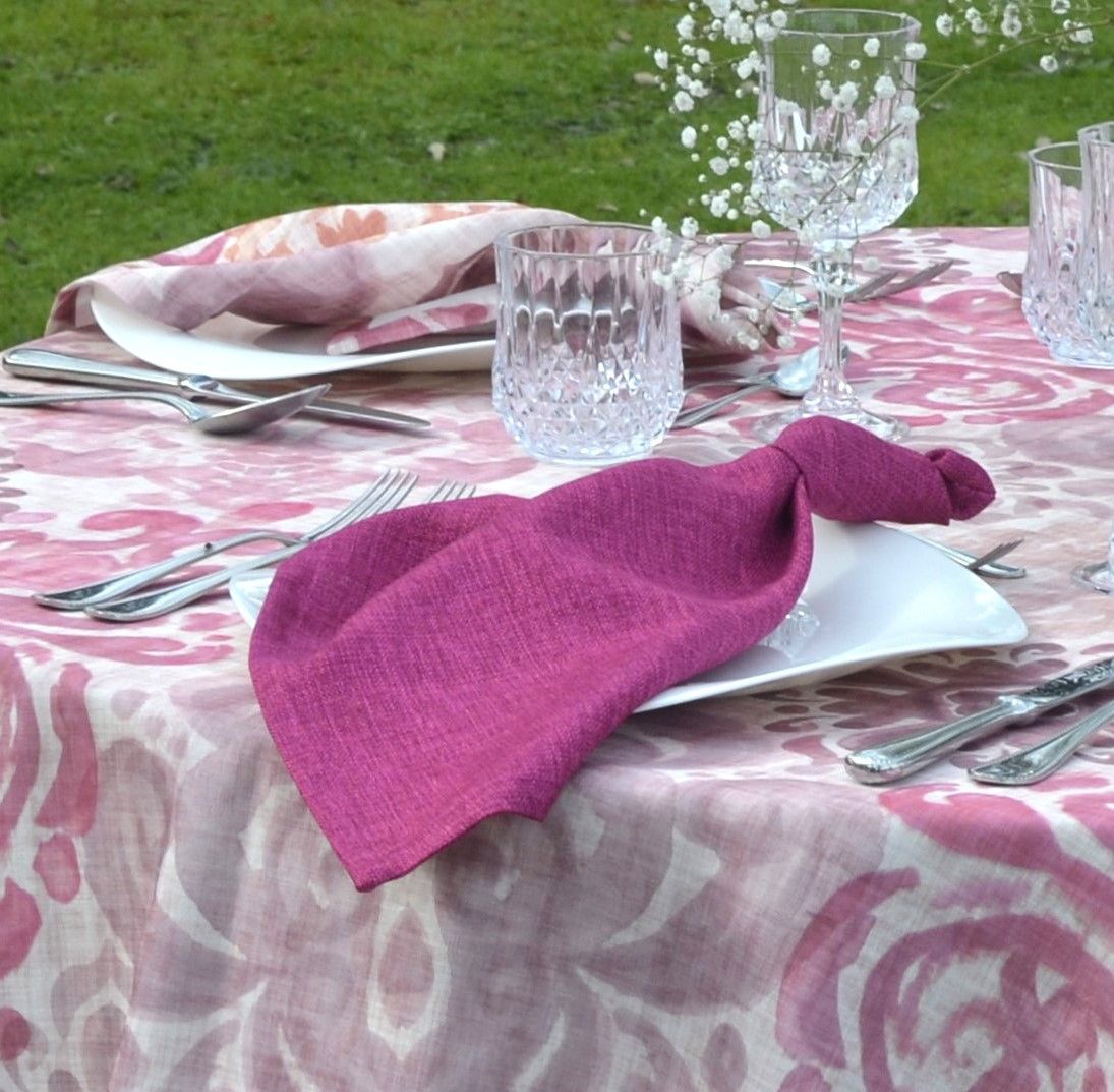 Una servilleta morada está sobre un plato sobre una mesa.