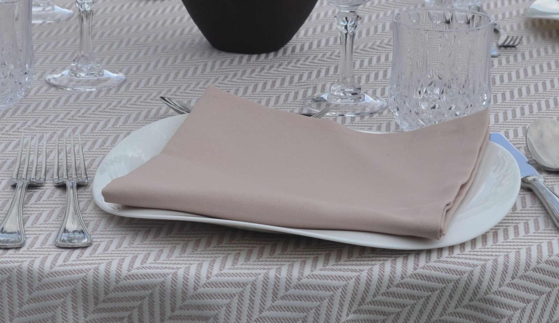 Una servilleta está sobre un plato blanco sobre una mesa.