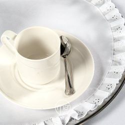 Una taza y un platillo con una cuchara en una bandeja.