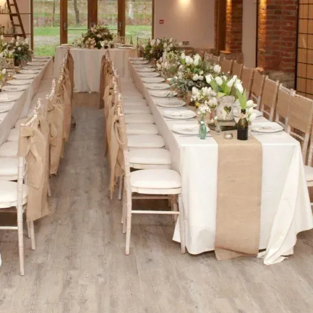 Una mesa larga con platos y flores encima.