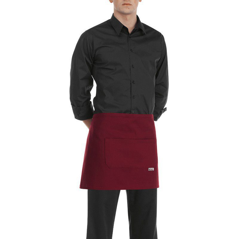 Un hombre que lleva una camisa negra y un delantal rojo.