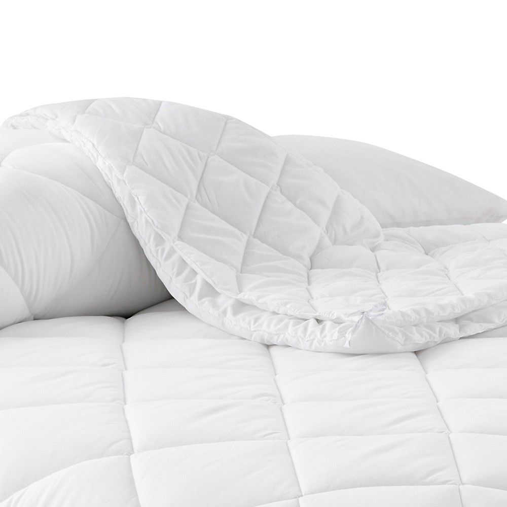 Un edredón blanco está encima de una cama.