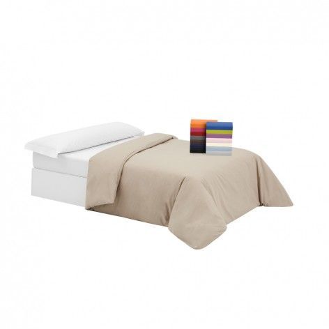 Una cama con un edredón y almohadas encima.