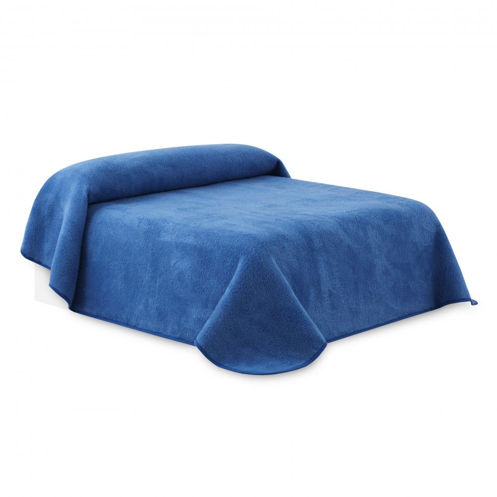 Una cama con una manta azul encima
