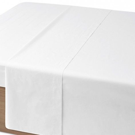 Un mantel blanco está sobre una mesa de madera.