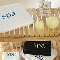 Una toalla blanca con la palabra spa bordada.