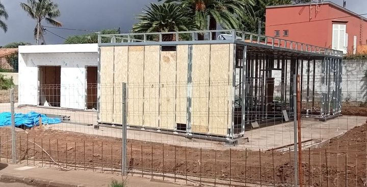 Se está construyendo una casa en un campo con una valla alrededor.
