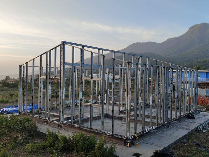 Se está construyendo una casa en un campo con una valla alrededor.